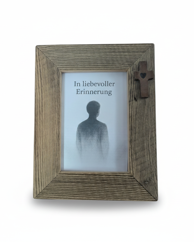 Bilderrahmen aus Altholz in rustikalem Stil zur Erinnerung an Verstorbene mit dunklem Kreuz in der oberen, rechten Ecke. 