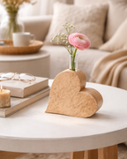Moderne Holzvase in Herzform mit Blumenstrauß als Tischdekoration. 