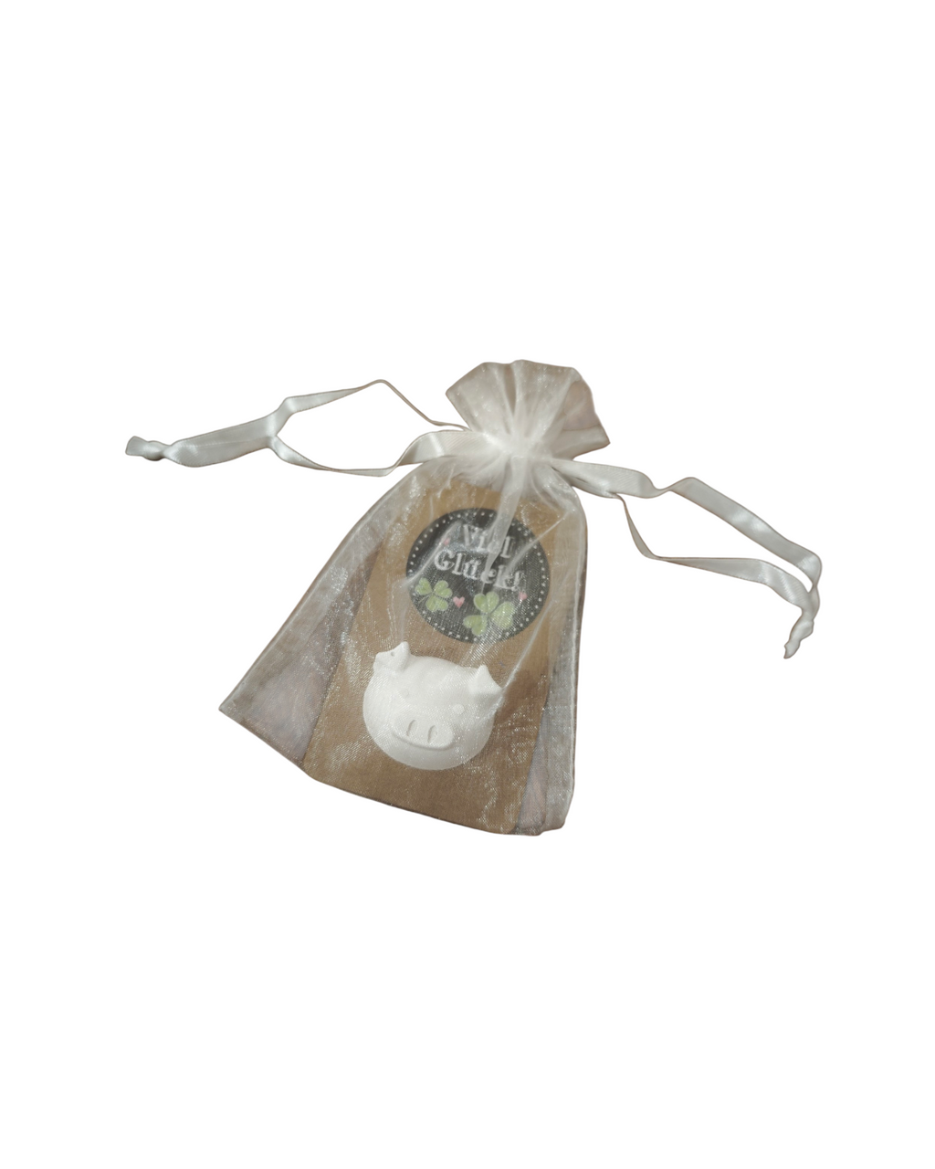 Ein aus Gips gegossener Glücksbringer in Form eines Schweinchens, schön verpackt in einem kleinen Säckchen. 