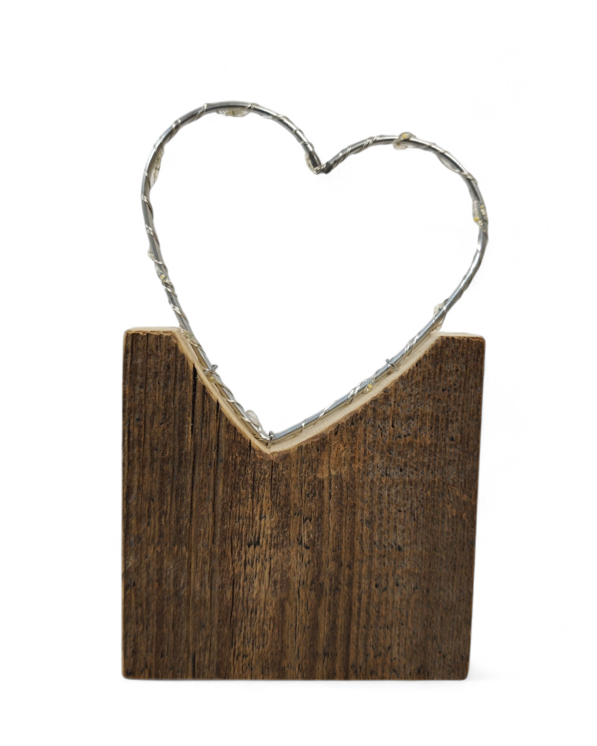 Herz mit LED Lichterkette umwickelt auf Sockelständer aus Altholz. 