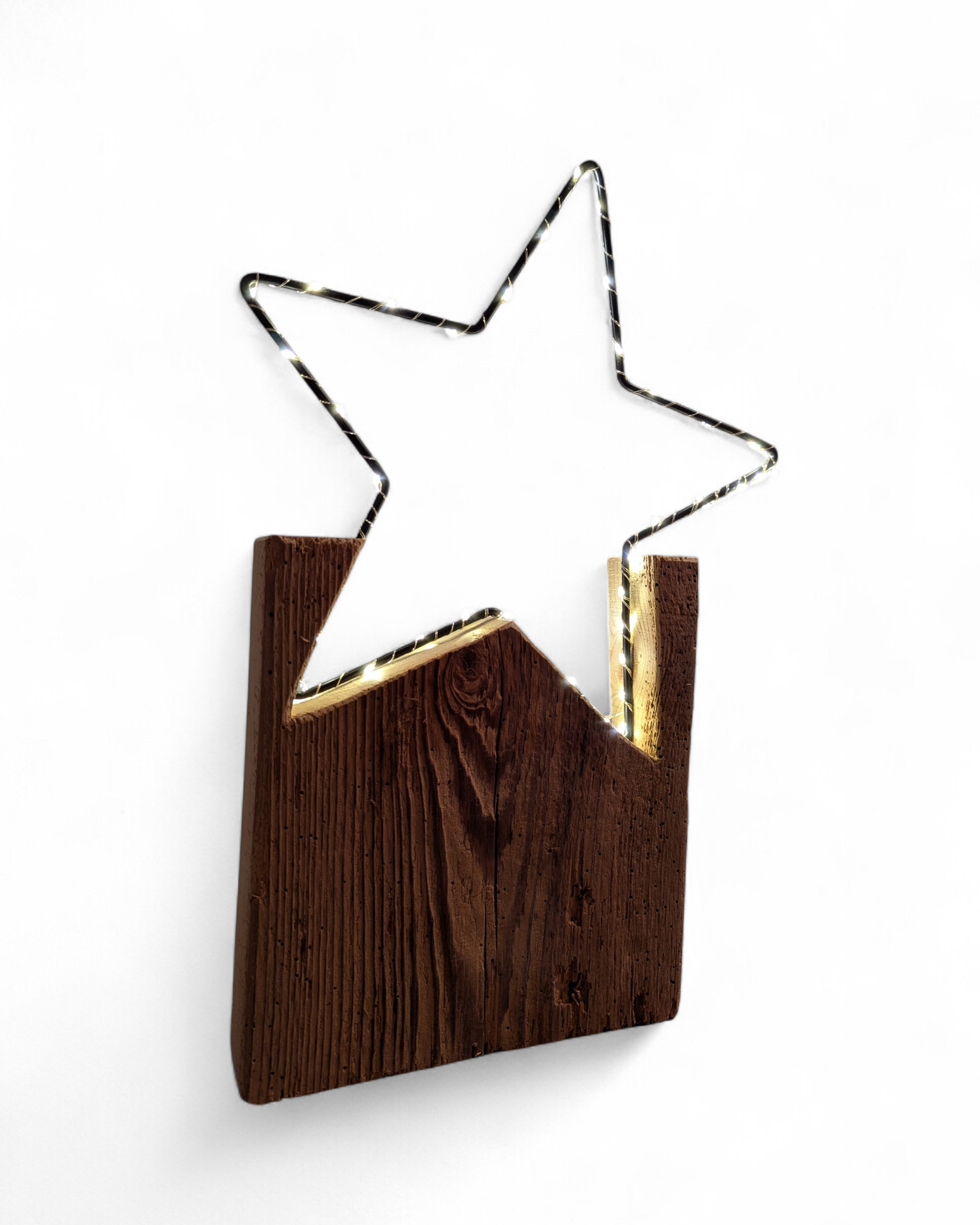 Metallstern mit LED Lichterkette umwickelt auf Sockelständer aus Altholz. 