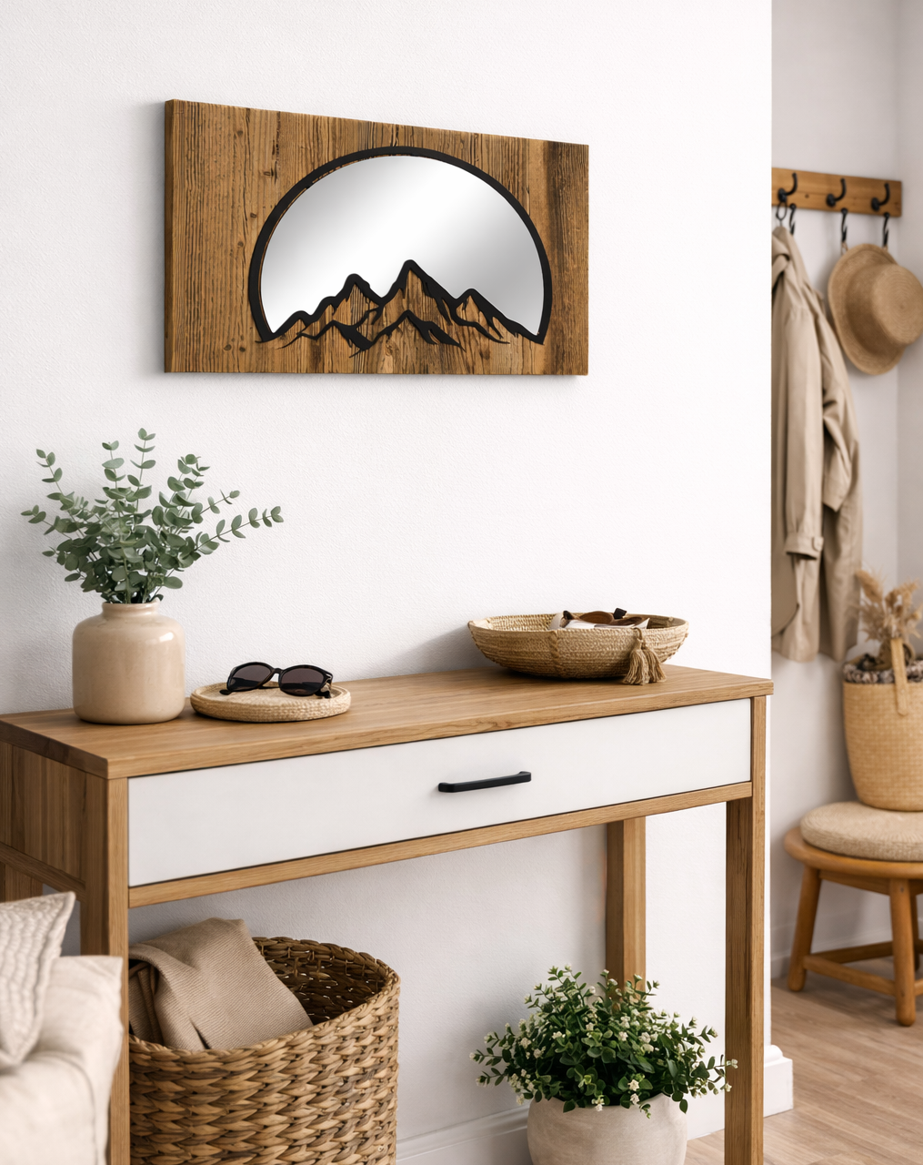 Wohnliche Szene im Eingangsbereich mit Fokus auf einen Spiegel mit metallischer Berglandschaft auf Altholzbrettern. 